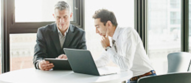 two business men looking at laptop