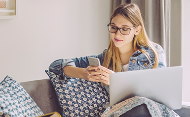 woman on couch using mobile phone